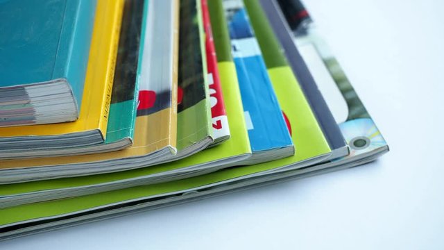 Magazines with selective focus on foreground edge. Edge stack of the colorful magazines