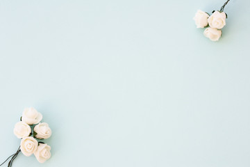 Styled stock photo. Feminine wedding desktop mockup. White roses on delicate blue background. Copy space. Top view. Picture for blog.