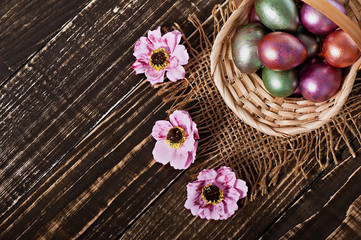 Fototapeta na wymiar Easter eggs in a basket on an old wooden background.