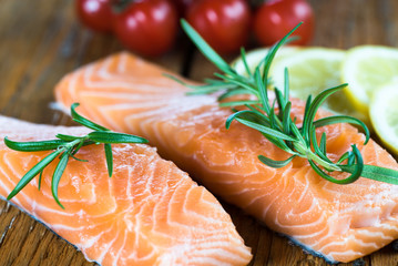 Delicious portion of fresh salmon fillet with aromatic herbs, spices and vegetables - healthy food, diet or cooking concept