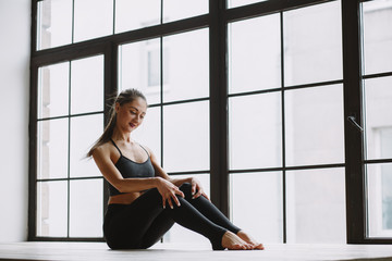 Fototapeta na wymiar Young woman doing yoga at light window