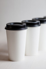 Coffee in blank white paper cups takeaway with caps. on white background.