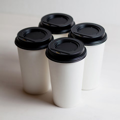 Coffee in blank white paper cups takeaway with caps. on white background.