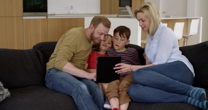 Young family play on tablet in contemporary modern home, in slow motion