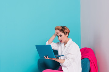 Close up portrait of tired girl with dissatisfied face expression, looking at her notebook screen with copy space for your advertising content, reading information on the Internet using laptop