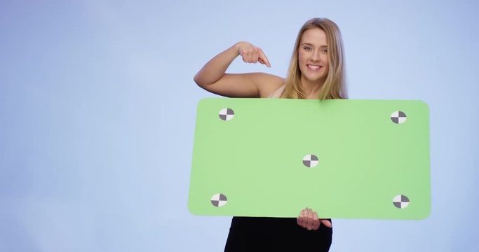Very attractive Woman holding oversized blank Card and pointing on it
