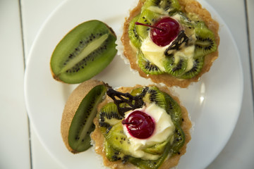 Delicious fruit cake with curd cream with kiwi and cherry