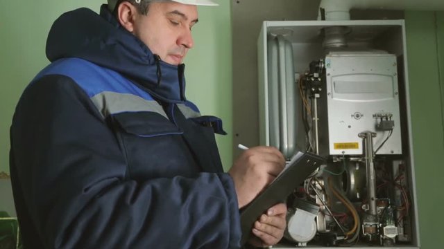 Worker checking gas-fire boiler