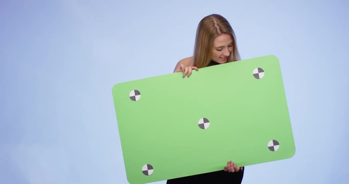 Happy smiling Woman holding oversized blank Card and looking into the Camera