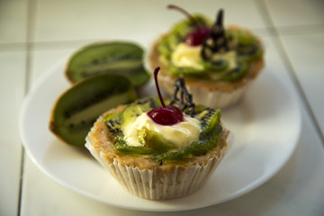 Delicious fruit cake with curd cream with kiwi and cherry