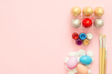 Flat lay top view colorful easter egg painted in pastel colors composition with paint brush on pink pastel color background. Easter day background top view with copy space.