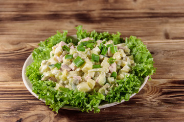 Traditional Russian festive salad Olivier on wooden table