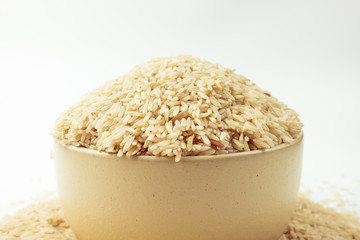 Thai organic rice in yellow bowl shot on white blackground.