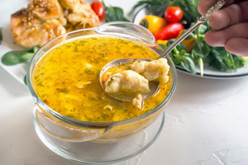 Soup with dumplings and meat on a wooden table, a portion of Bavarian soup griesnockerl, selective focus.