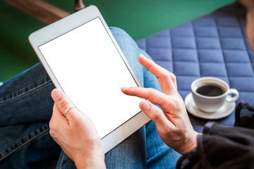 woman uses tablet while relaxing at home with coffee on the sofa bed