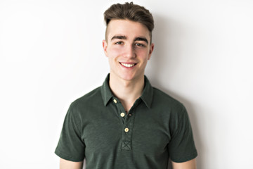 Fototapeta premium portrait of young smiling cute teenager in white wall