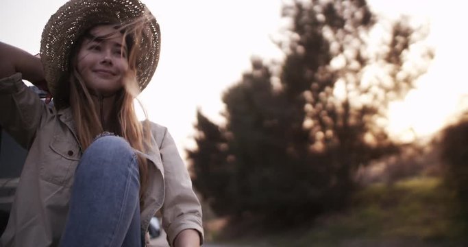 Beautiful girl sitting in the back of a pick-up truck
