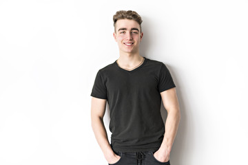 portrait of young smiling cute teenager in white wall