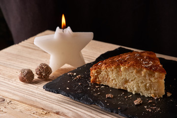 A piece of apple pie with grated chocolate near chocolate truffle candies. Selective focus and small depth of field.