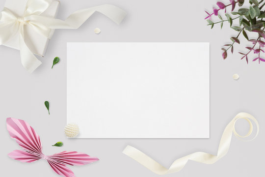Styled stock photo. Feminine wedding desktop mockup. White roses, satin ribbon, beads on delicate beige background. Copy space. Top view. Picture for blog.