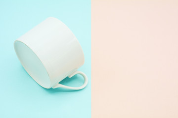 white ceramic coffee cup on blue and pink paper - background