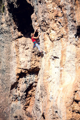 A woman climbs the rock.