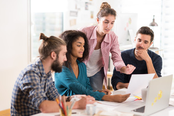 Young multiethnic creative team sharing ideas on a project 