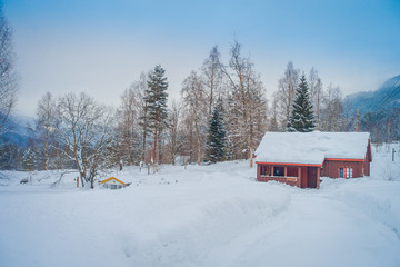 Fototapeta na wymiar Outdoor view of traditional Norwegian mountain houses of wood covered with snow in stunning nature in Norway