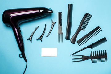 combs and hairdresser tools on blue background top view