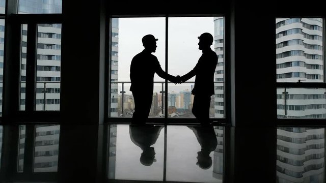 Partnership concept: two man silhouette handshake