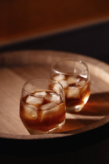 Glass of whiskey on wooden background close up