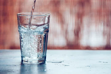 Foto op Canvas Koolzuurhoudend water in een drinkglas gieten © Bits and Splits