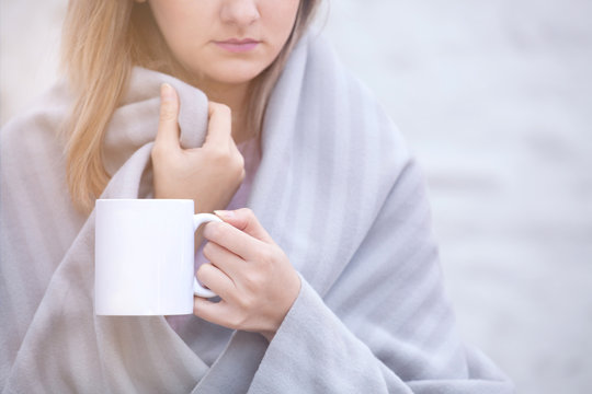 Close up portrait of woman drinking coffee in chilly morning 