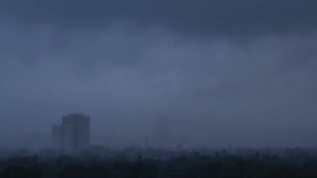 Dark rainstorm passing through city - time lapse