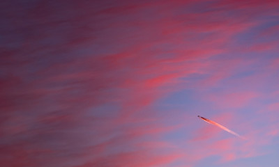Airplane against the background of red clouds