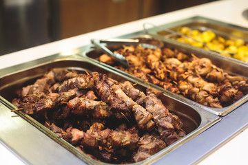 Beautifully decorated catering banquet table with different main course hot food dishes and garnish, with rice, chicken, lamb, vegetables and kebab on corporate party event or wedding celebration