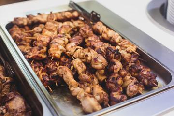 Beautifully decorated catering banquet table with different main course hot food dishes and garnish, with rice, chicken, lamb, vegetables and kebab on corporate party event or wedding celebration