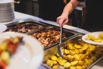 Beautifully decorated catering banquet table with different main course hot food dishes and garnish, with rice, chicken, lamb, vegetables and kebab on corporate party event or wedding celebration