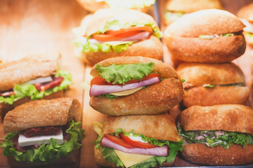 Beautifully decorated catering banquet table with different food snacks and appetizers with sandwich, on corporate christmas birthday kids party event or wedding celebration