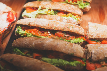 Beautifully decorated catering banquet table with different food snacks and appetizers with sandwich, on corporate christmas birthday kids party event or wedding celebration