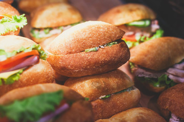 Beautifully decorated catering banquet table with different food snacks and appetizers with sandwich, on corporate christmas birthday kids party event or wedding celebration