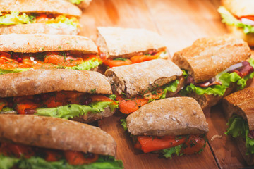 Beautifully decorated catering banquet table with different food snacks and appetizers with sandwich, on corporate christmas birthday kids party event or wedding celebration