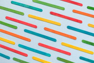 Multicolored ice cream sticks texture on blue background.