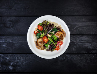 Salad with fried quail with tomatoes and lettuce.