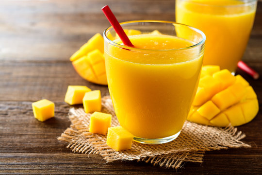 Mango Smoothie In Glass On Dark Wooden Background