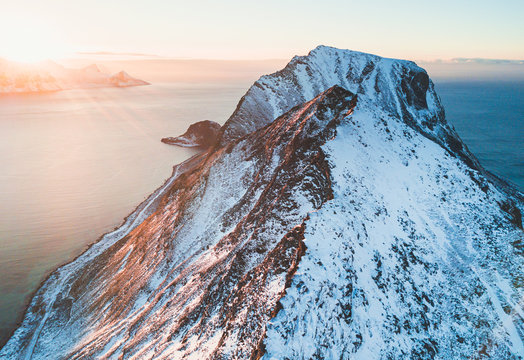 Norwegian winter sunny mountain landscape blue sky view with mountains, fjord, Norway, Ryten peak - famous mountain in Lofoten Islands, Moskenes municipality, Nordland, shot from drone