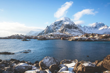 Beautiful super wide-angle winter snowy view of fishing village A, Norway, Lofoten Islands, with skyline, mountains, famous fishing village with red fishing cabins, Moskenesoya, Nordland