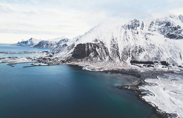 Aerial winter view of Lofoten Islands, Nordland, Norway, with fjord, road, bridge and mountains, shot from drone