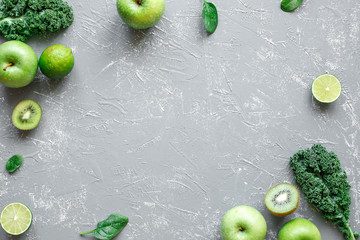 Fresh green fruits, kale and spinach on gray background with copy space, top view