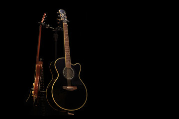 Acoustic guitar and electric guitar on the stage, on a black background - 198239102